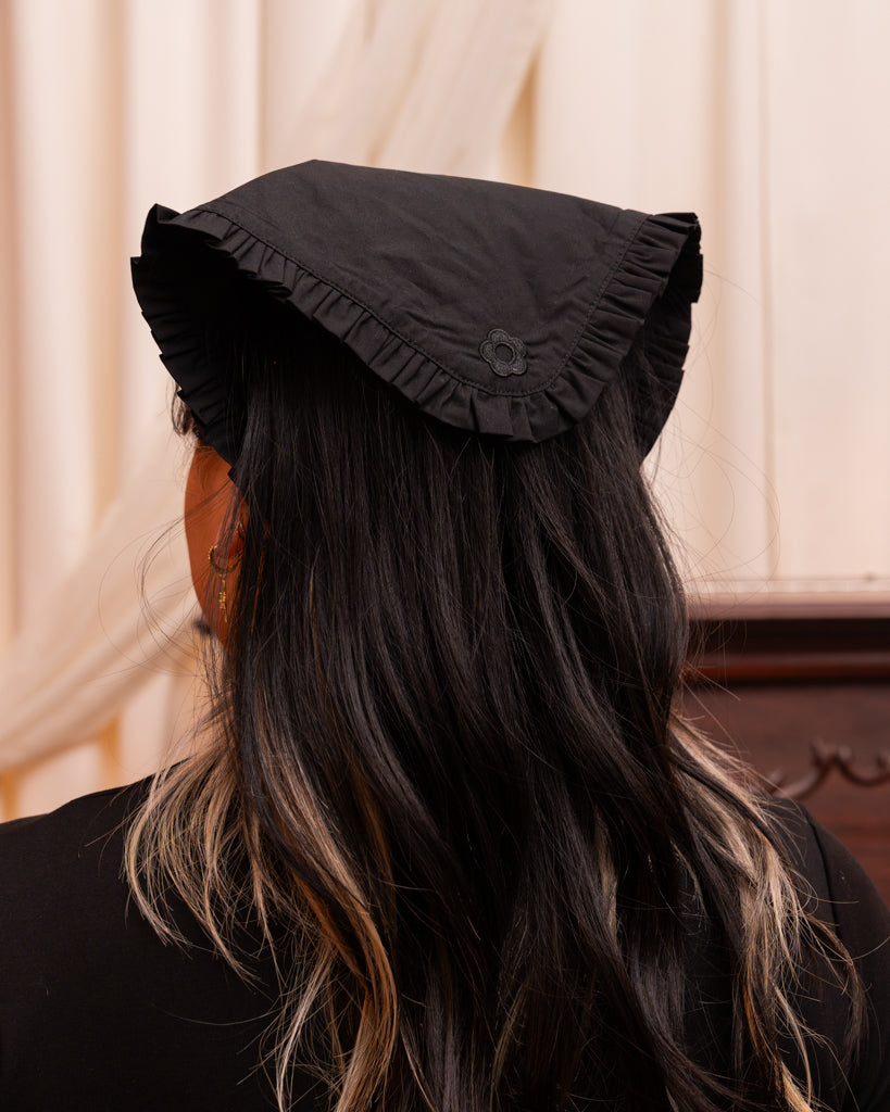 Back view of model wearing belle black bandanna, showing black embroidered flower.