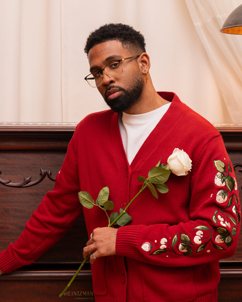 Man wearing berry blend cardigan in size large holding a white rose.