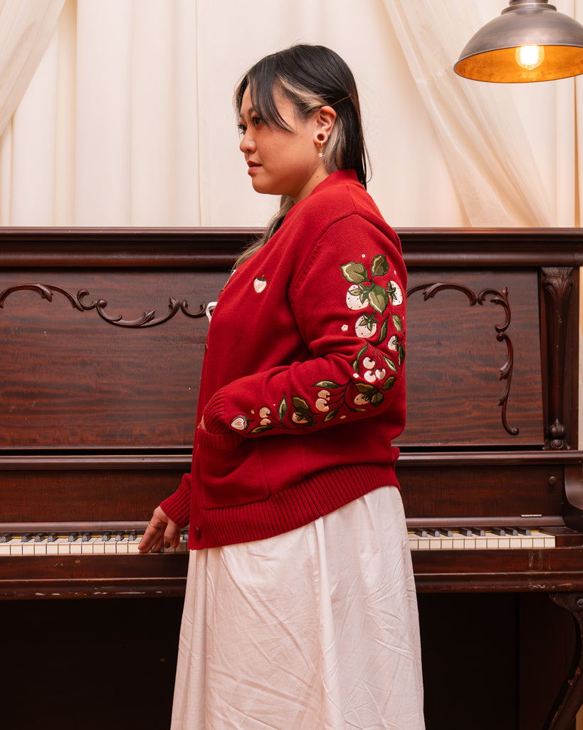 Side view of berry blend cardigan in size large, showcasing embroidered strawberries going down sleeve.