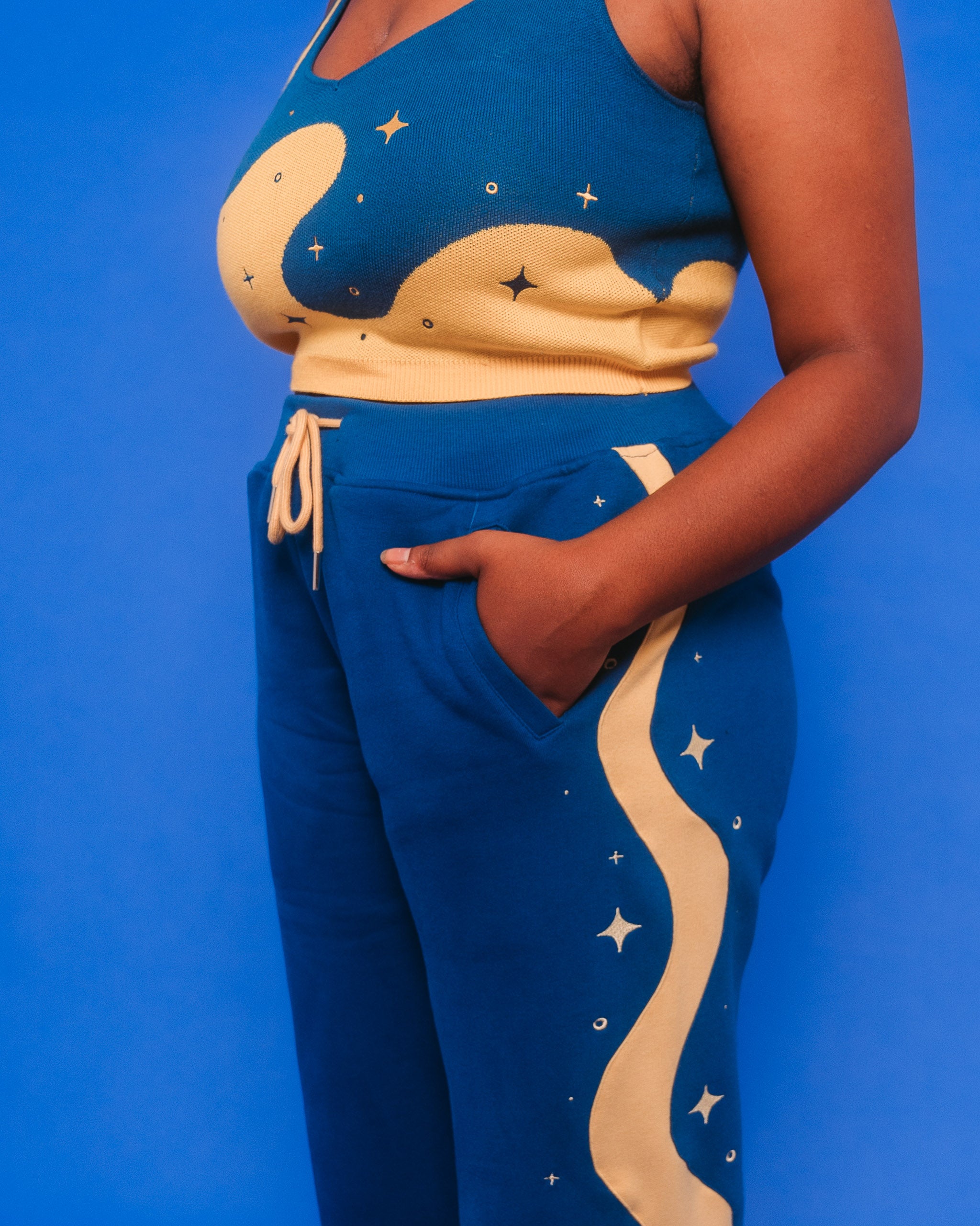 Side view of blue moon joggers showcasing yellow wavy stripe and sparkles going downwards.