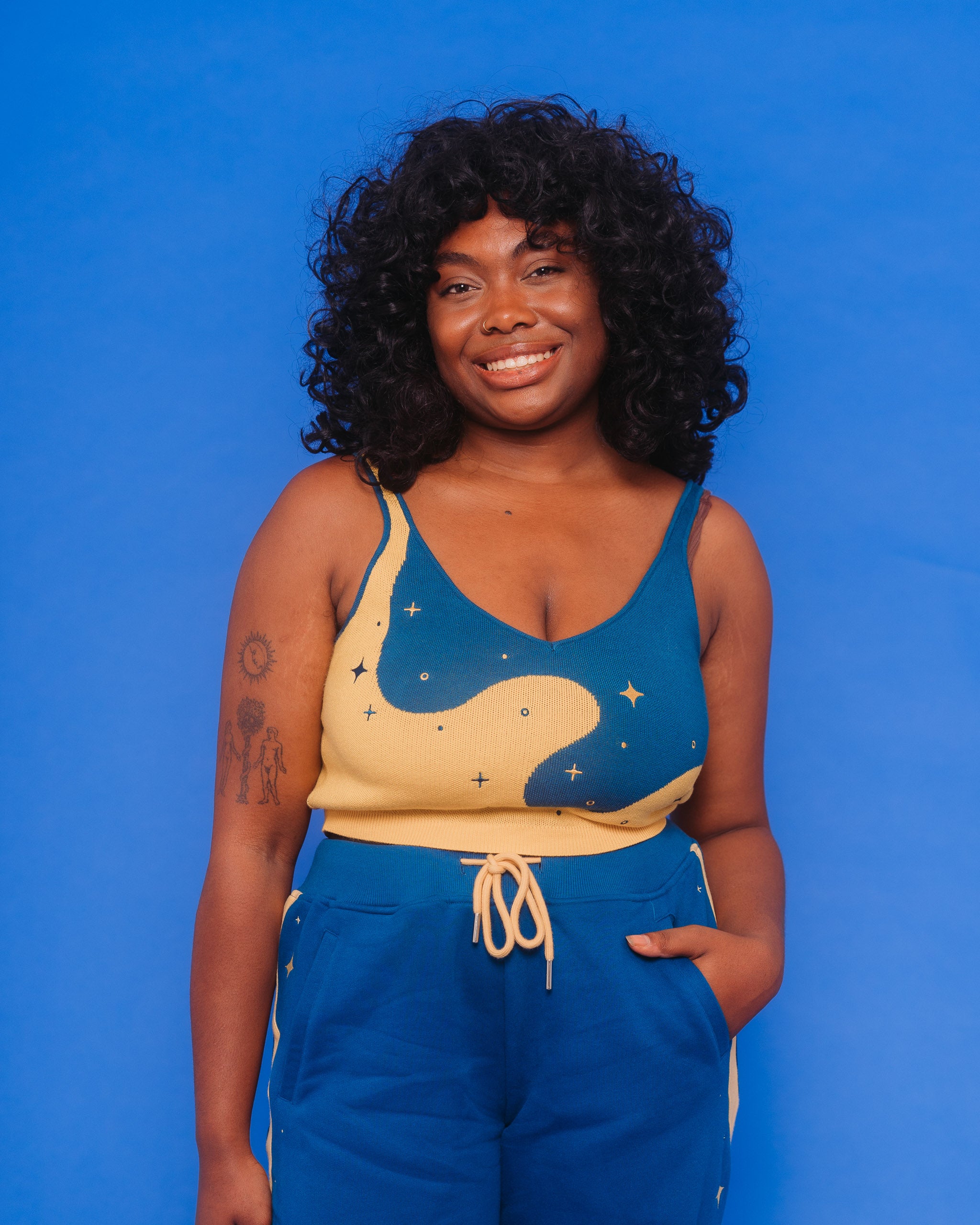 Woman wearing blue moon knit tank in size large in front of blue background.