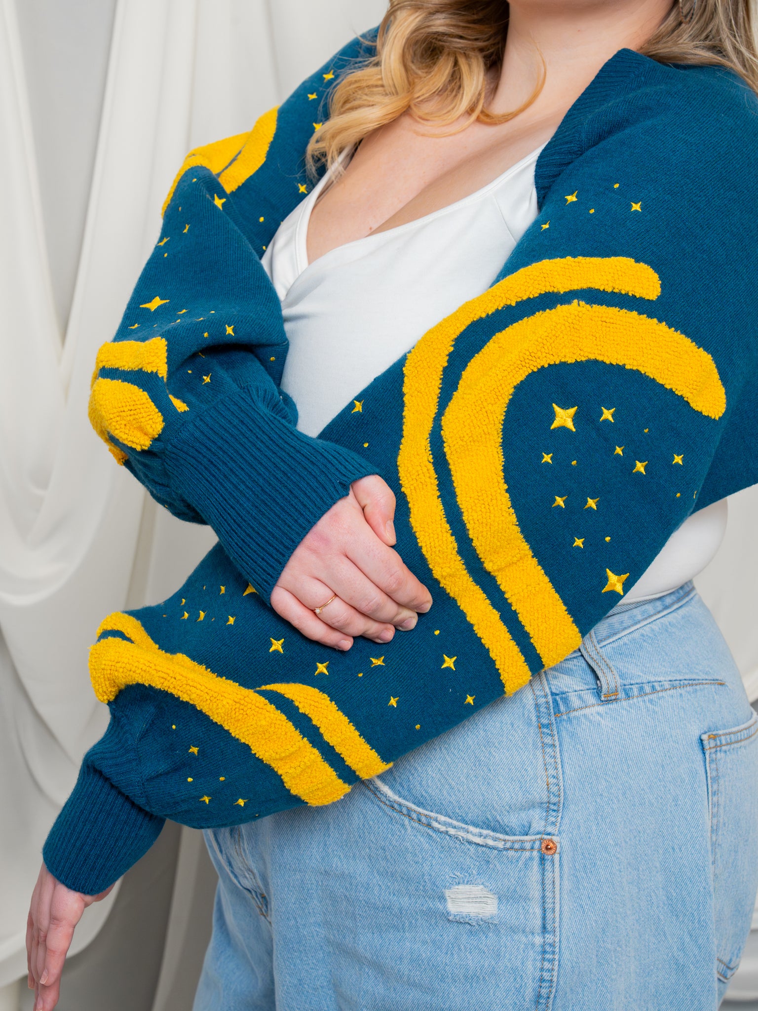 Sleeve close up of blue and yellow blue moon bolero showcasing yellow wavy detail and yellow embroidered sparkles.