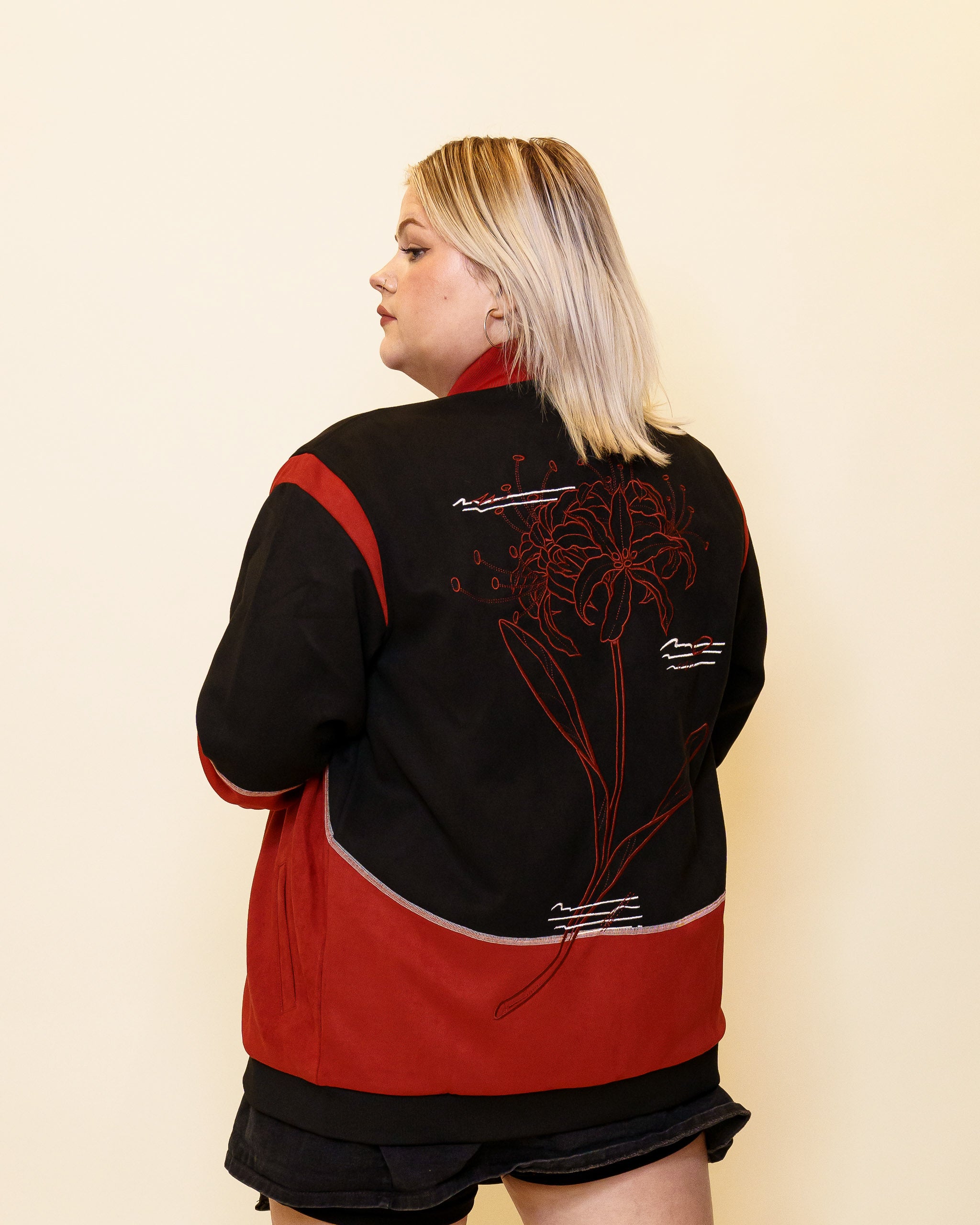 Woman wearing calling card faux-suede jacket in size large glancing over her shoulder.