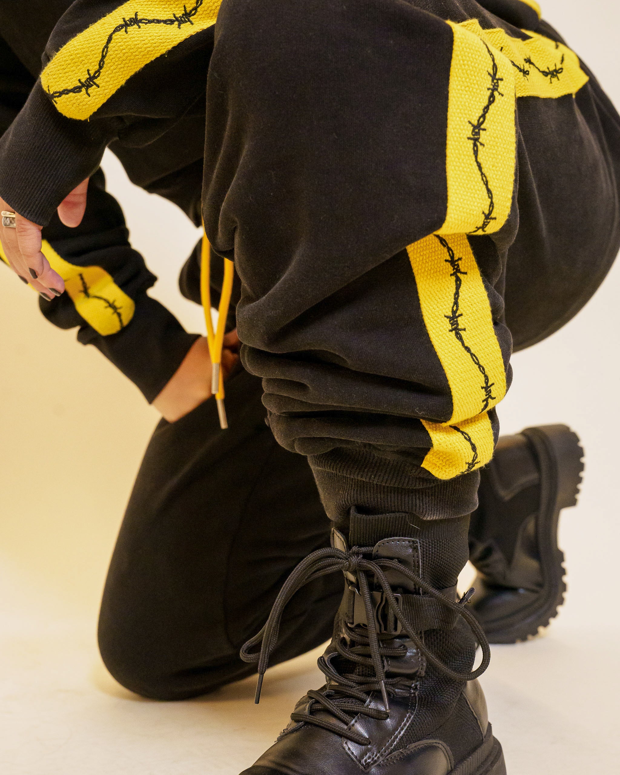 Close up of caution joggers side stripe detail with barbed wire graphic.