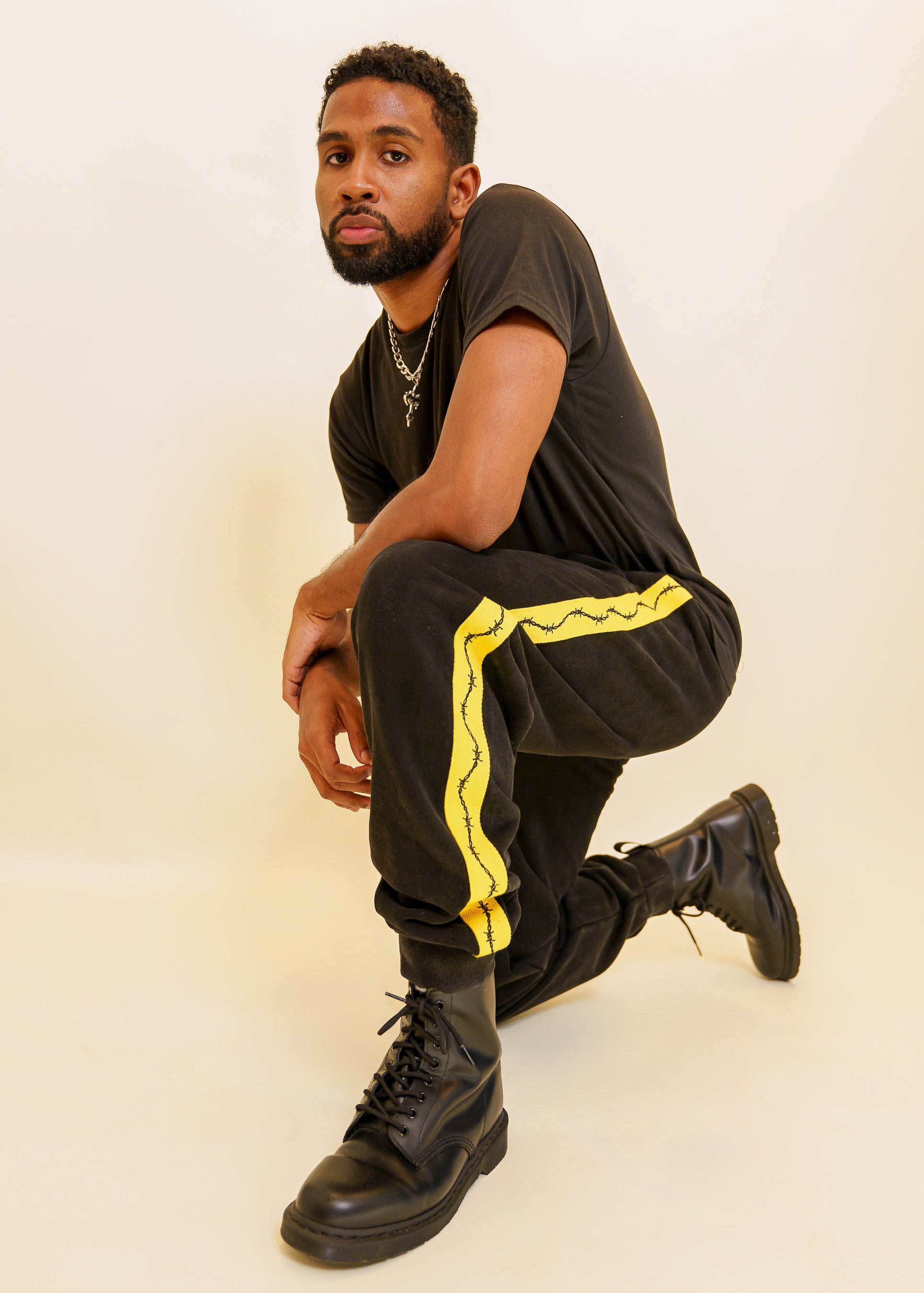 Man crouched down wearing caution joggers in size large.