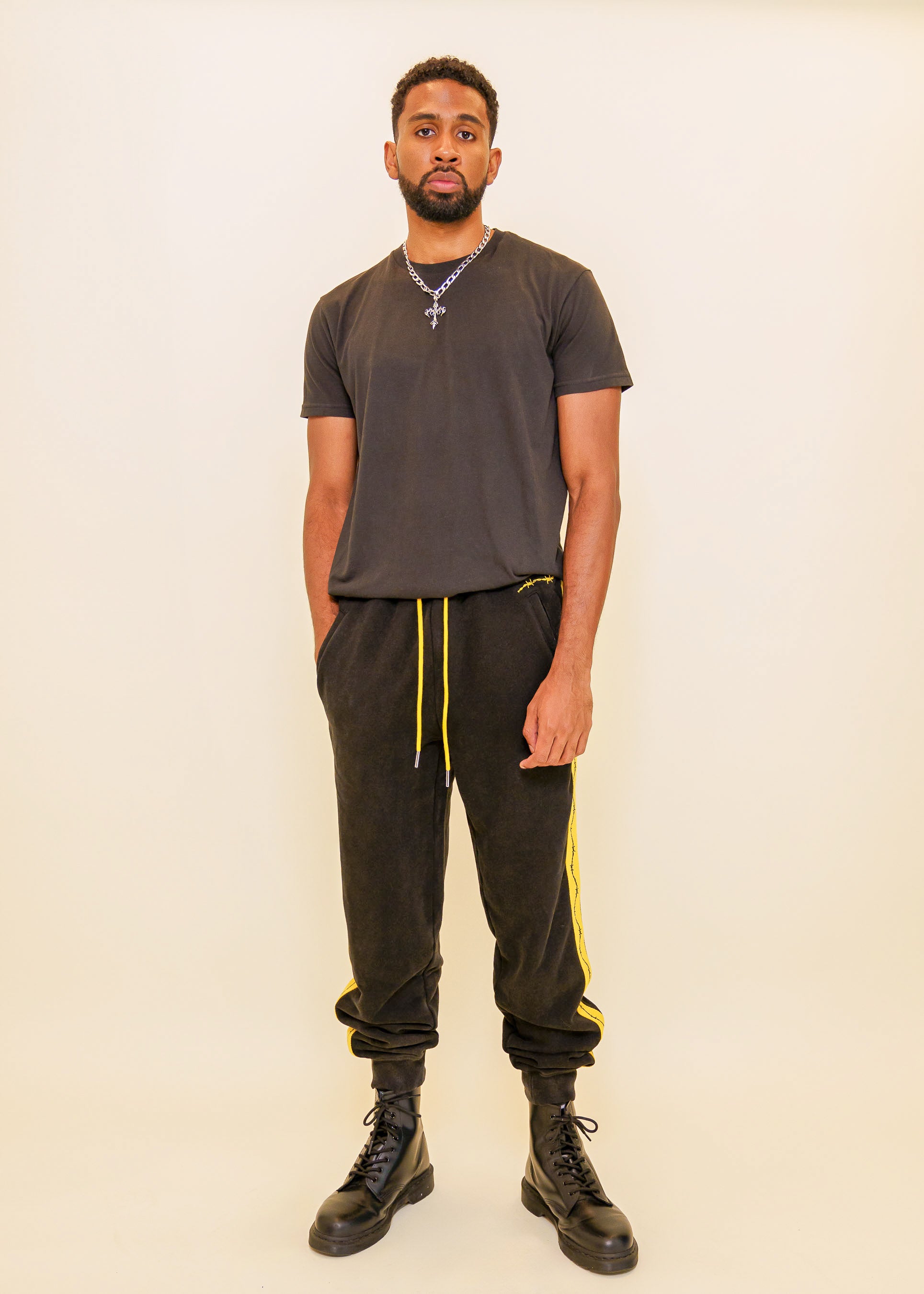 Man wearing caution joggers in size extra large in front of off-white background.
