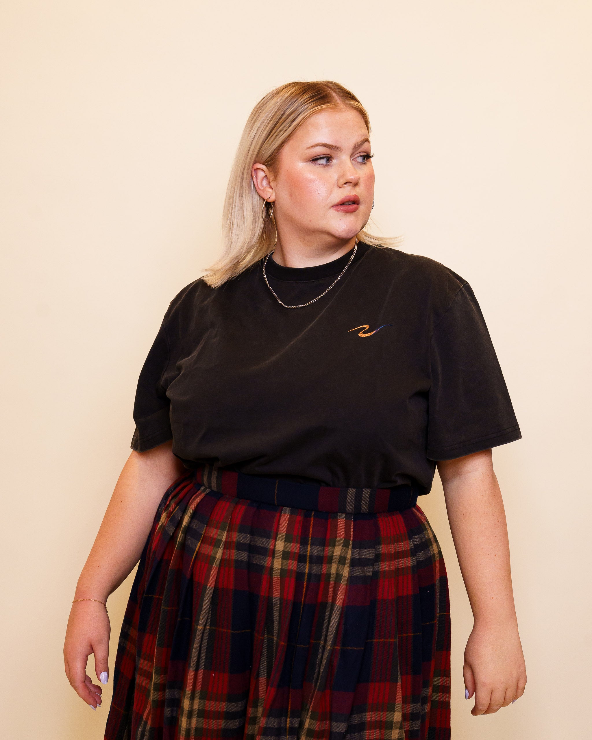 Woman wearing cold case tee in size 48 glancing to the side.