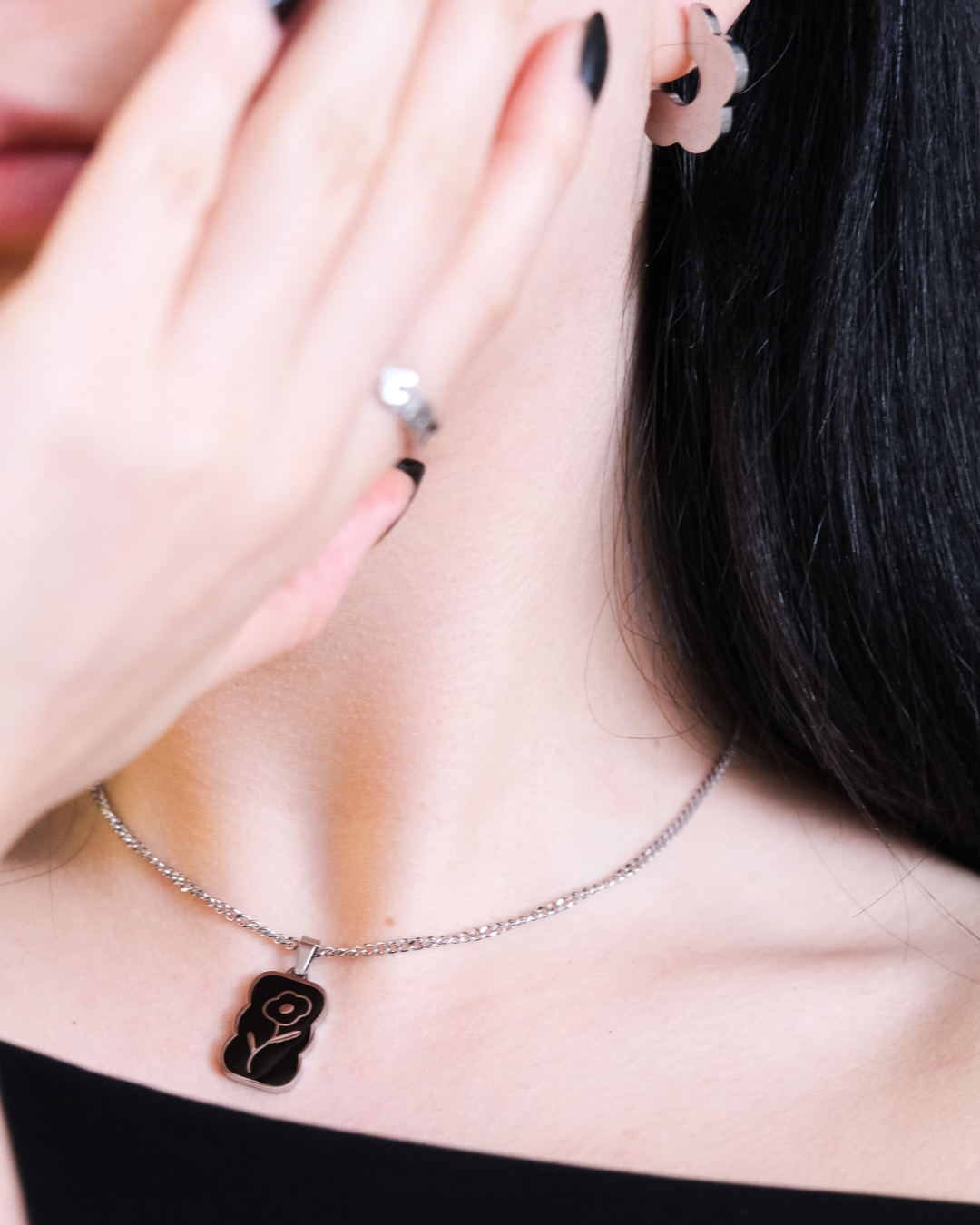 Daisy enamel pendant in silver being worn.