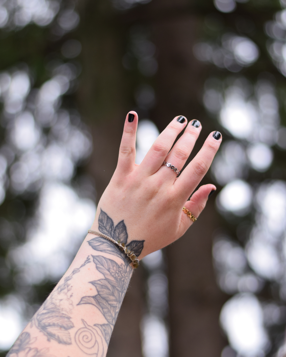 Hand wearing both silver and gold daisy rings.