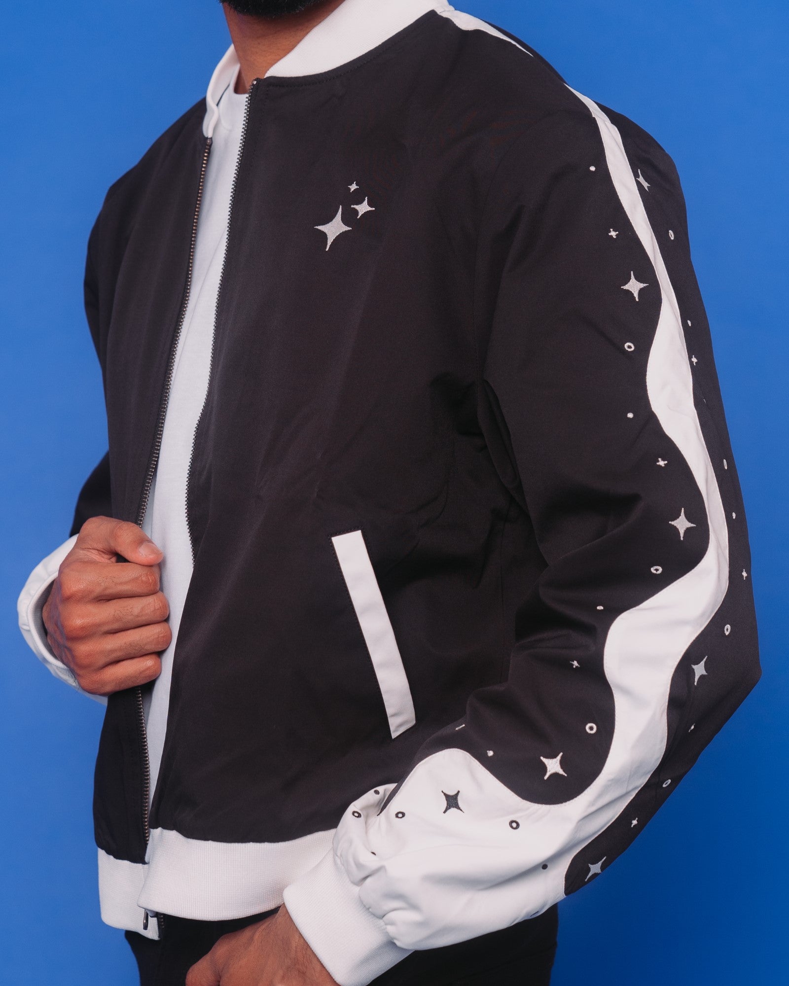 Man wearing deep space bomber jacket in size extra large, showing sleeve sparkle details.