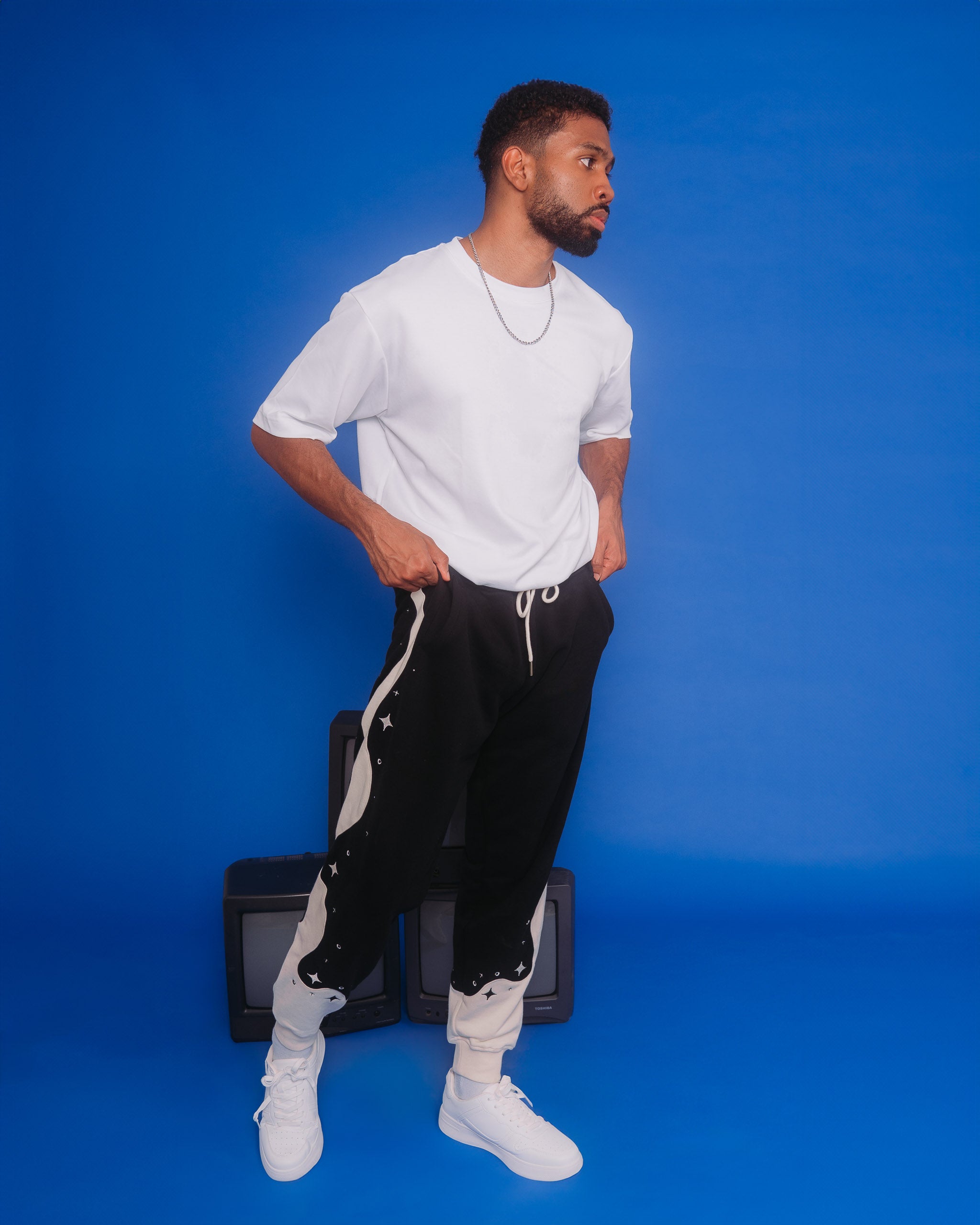 Man wearing deep space joggers in size large in front of blue background.