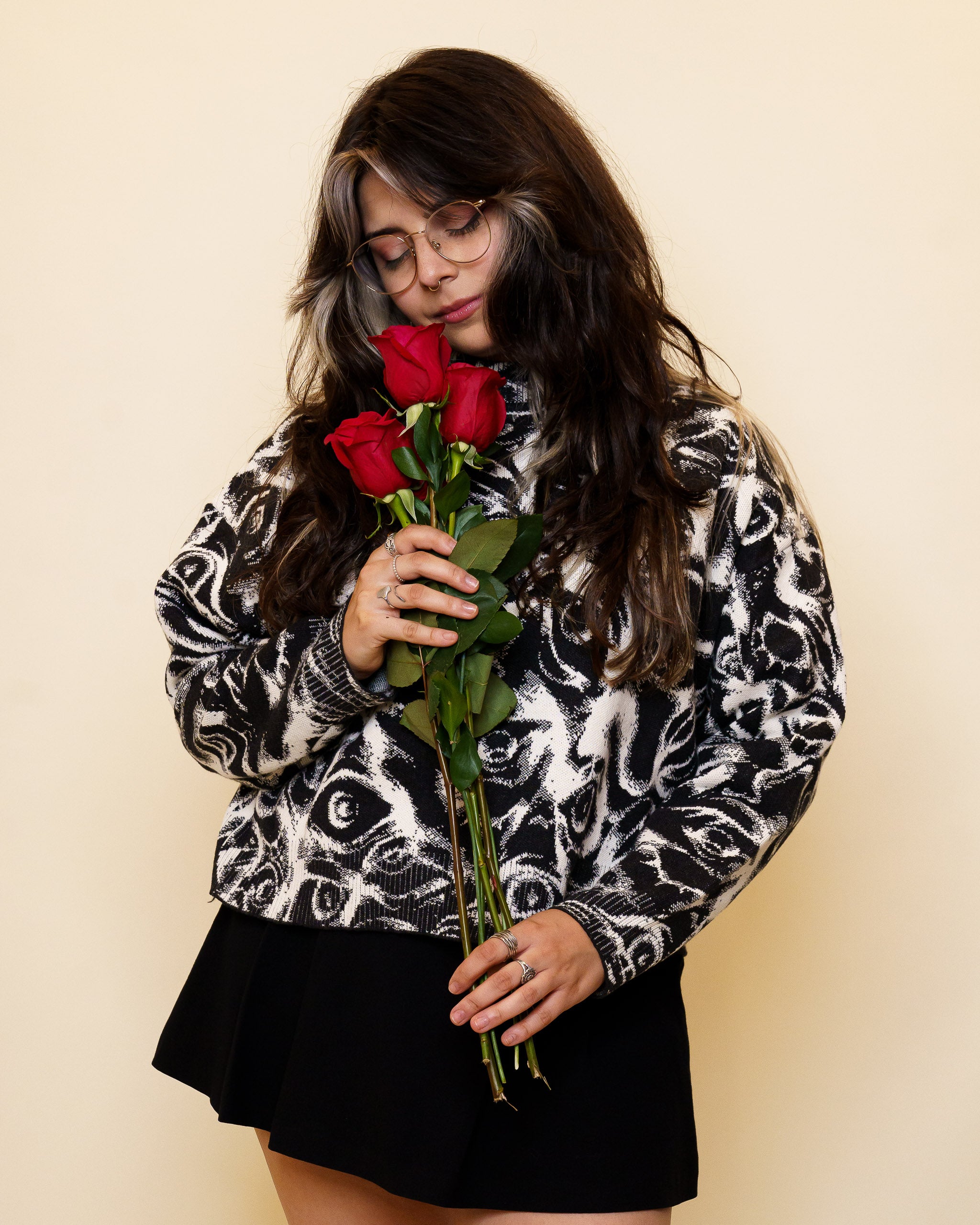 Woman wearing eyes on you cropped knit sweater in size small holding roses.