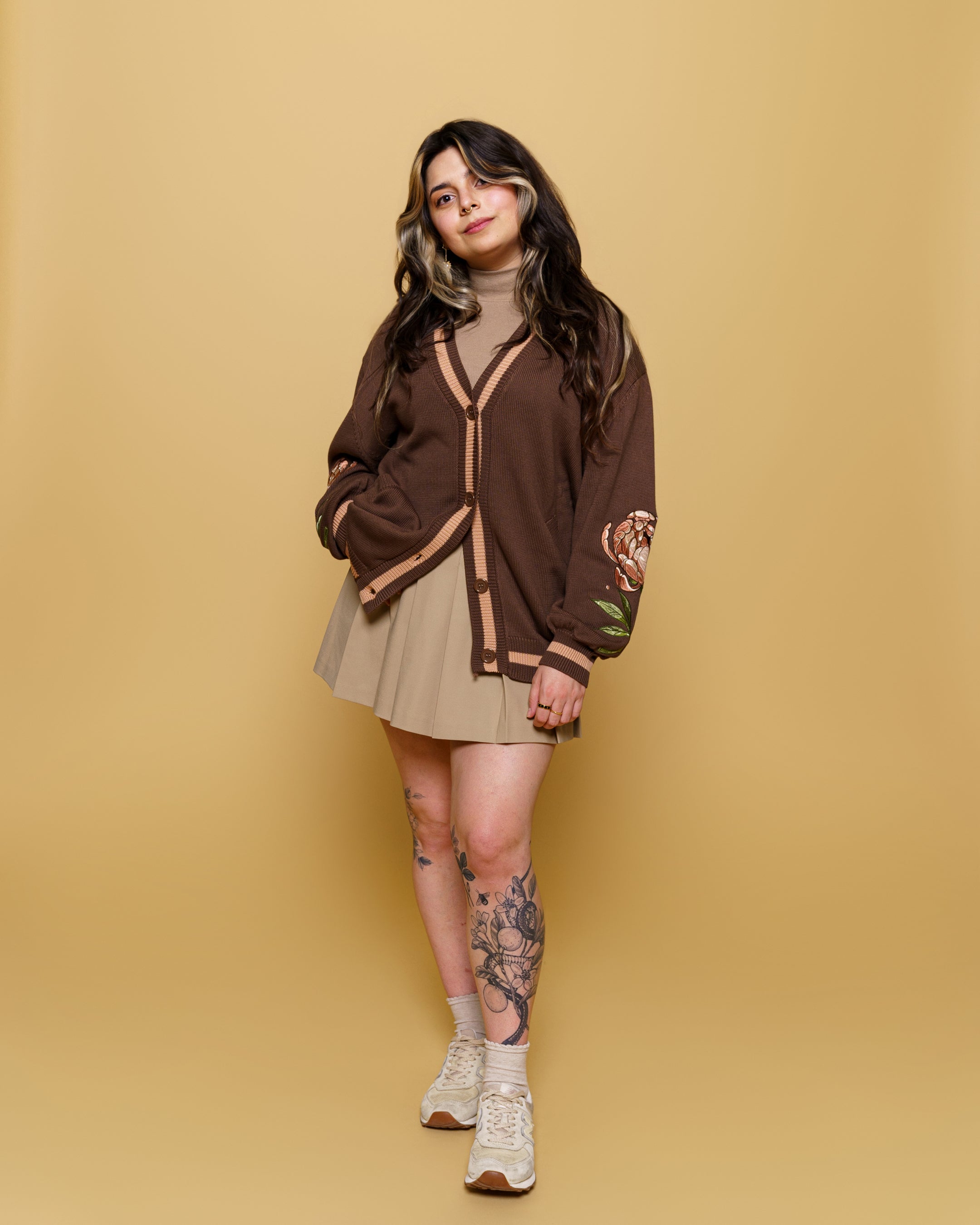 Woman wearing freshly picked cotton cardigan in size small in front of soft yellow background.