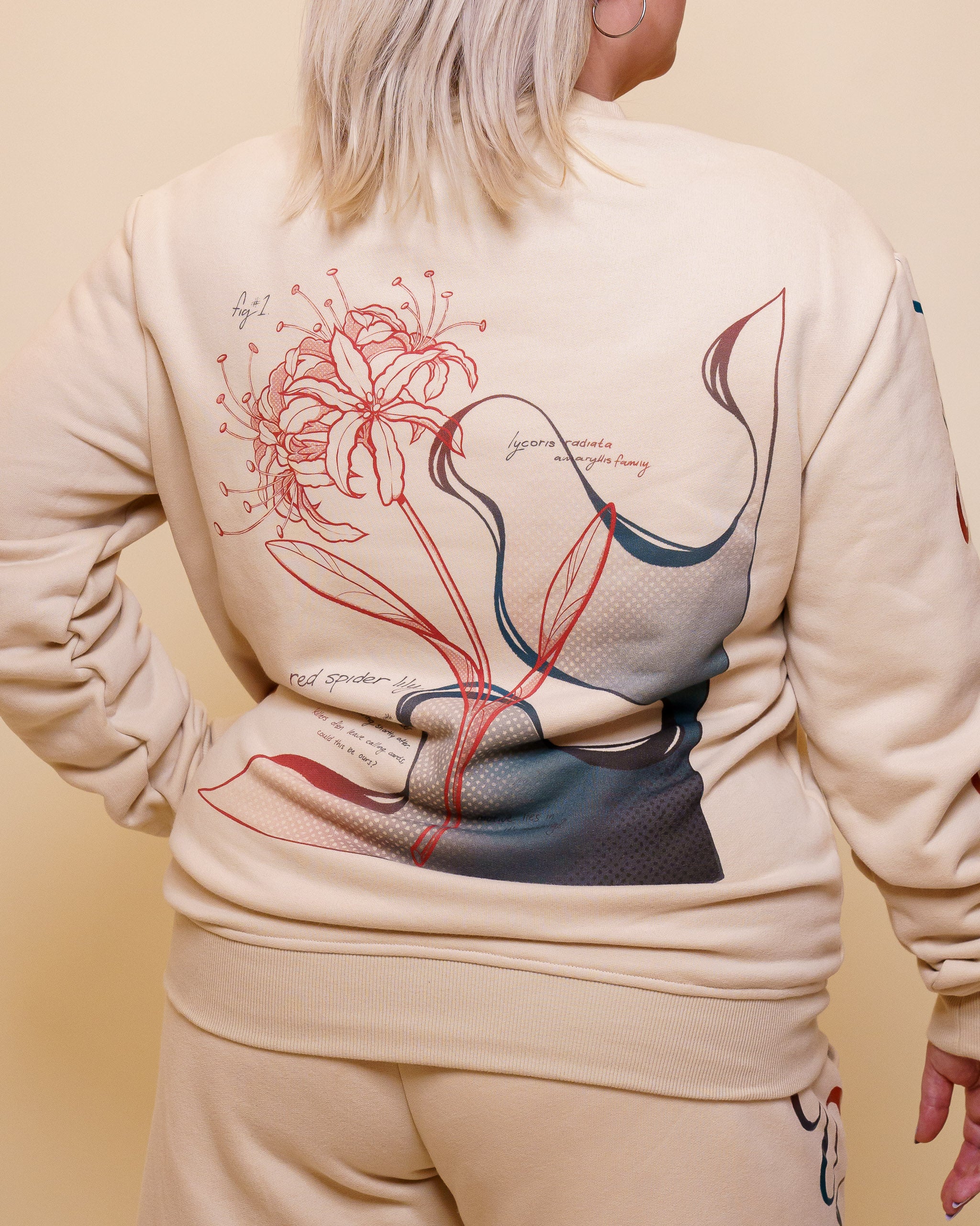 Back view of woman wearing intuition crewneck showing design with flower and text.