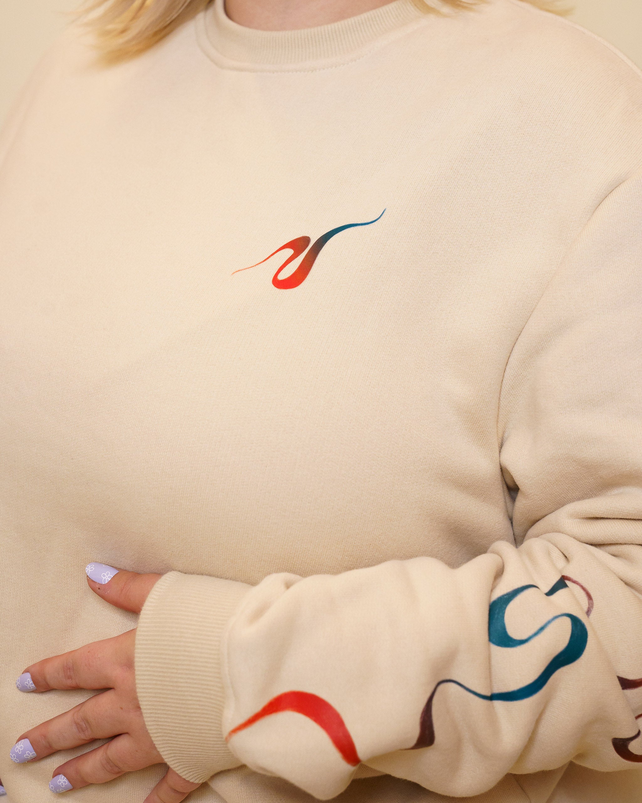 Frontal close up of intuition crewneck wavy red and blue gradient line detail.