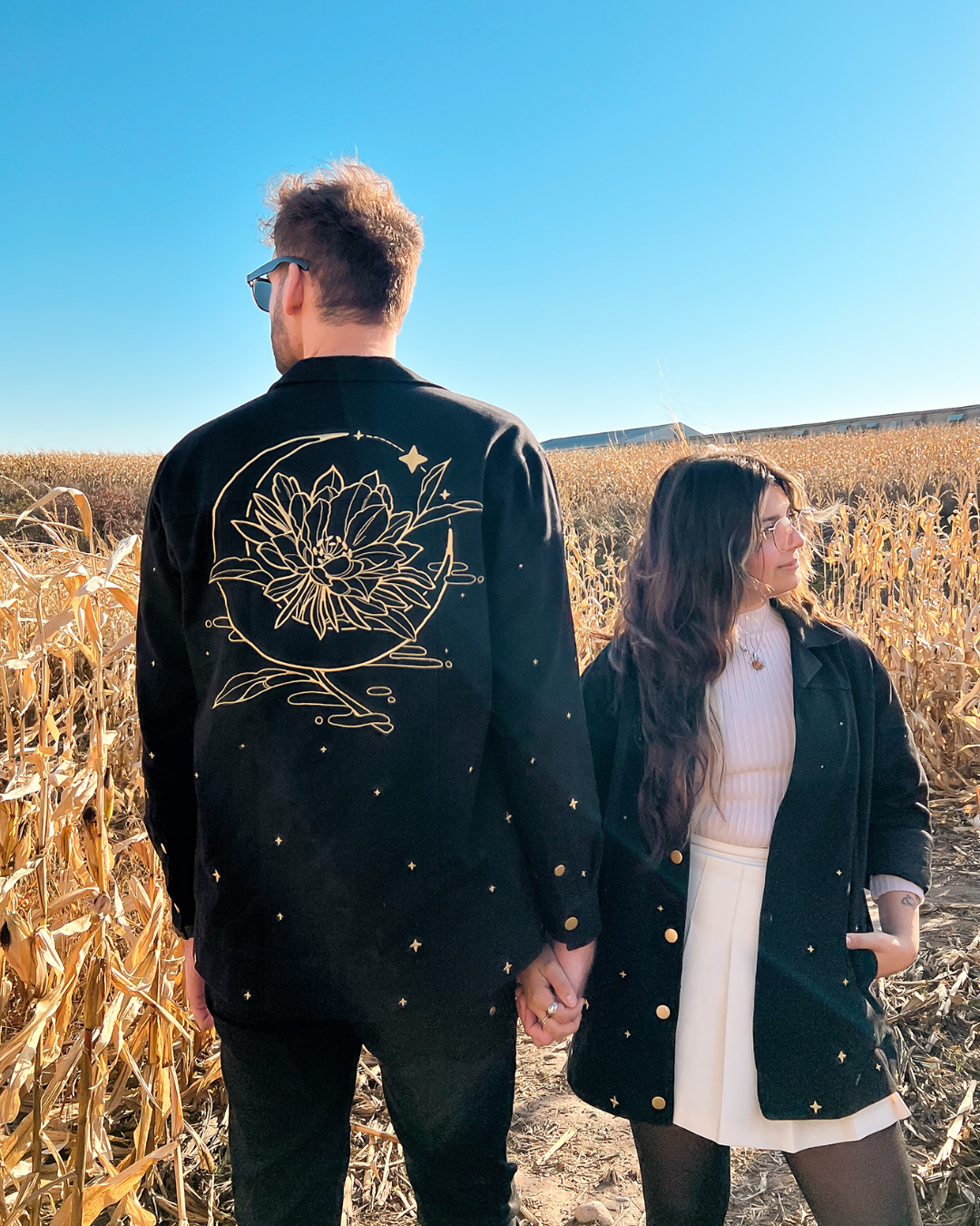 Man and woman wearing night bloom jackets.