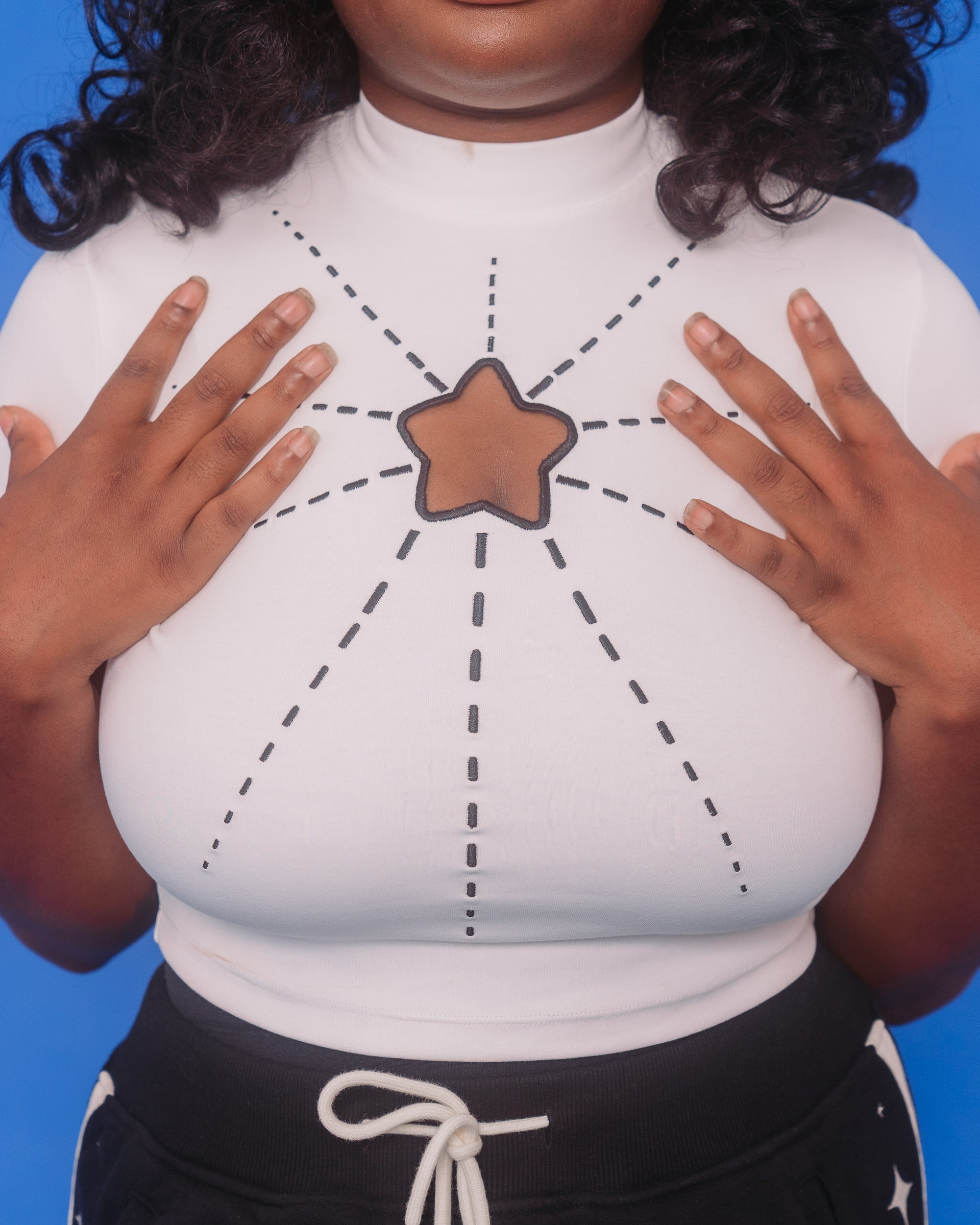 Close up of white supernova mini tee star cutout and embroidered lines creating a starburst look.