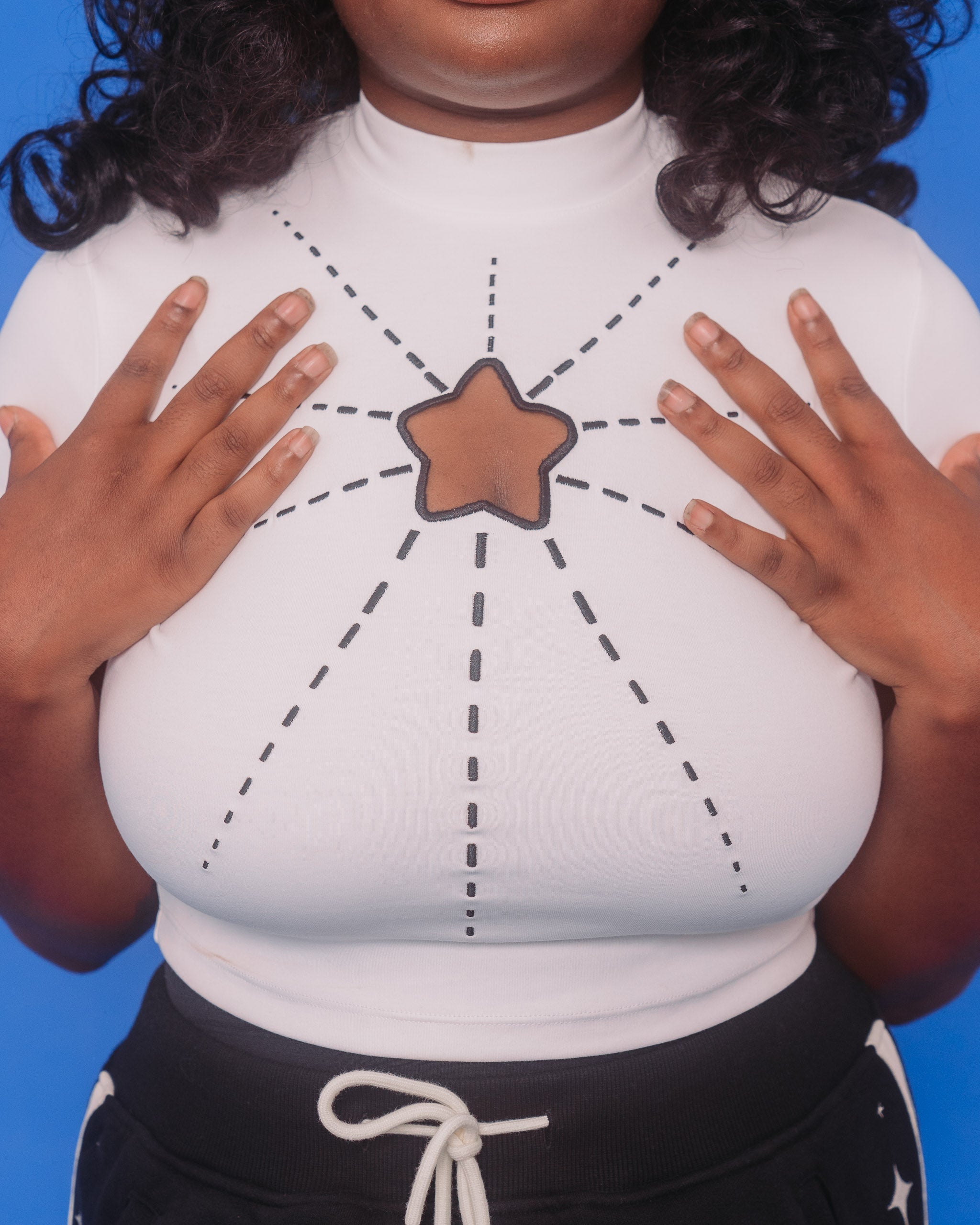 Close up of white supernova mini tee star cutout and embroidered lines creating a starburst look.
