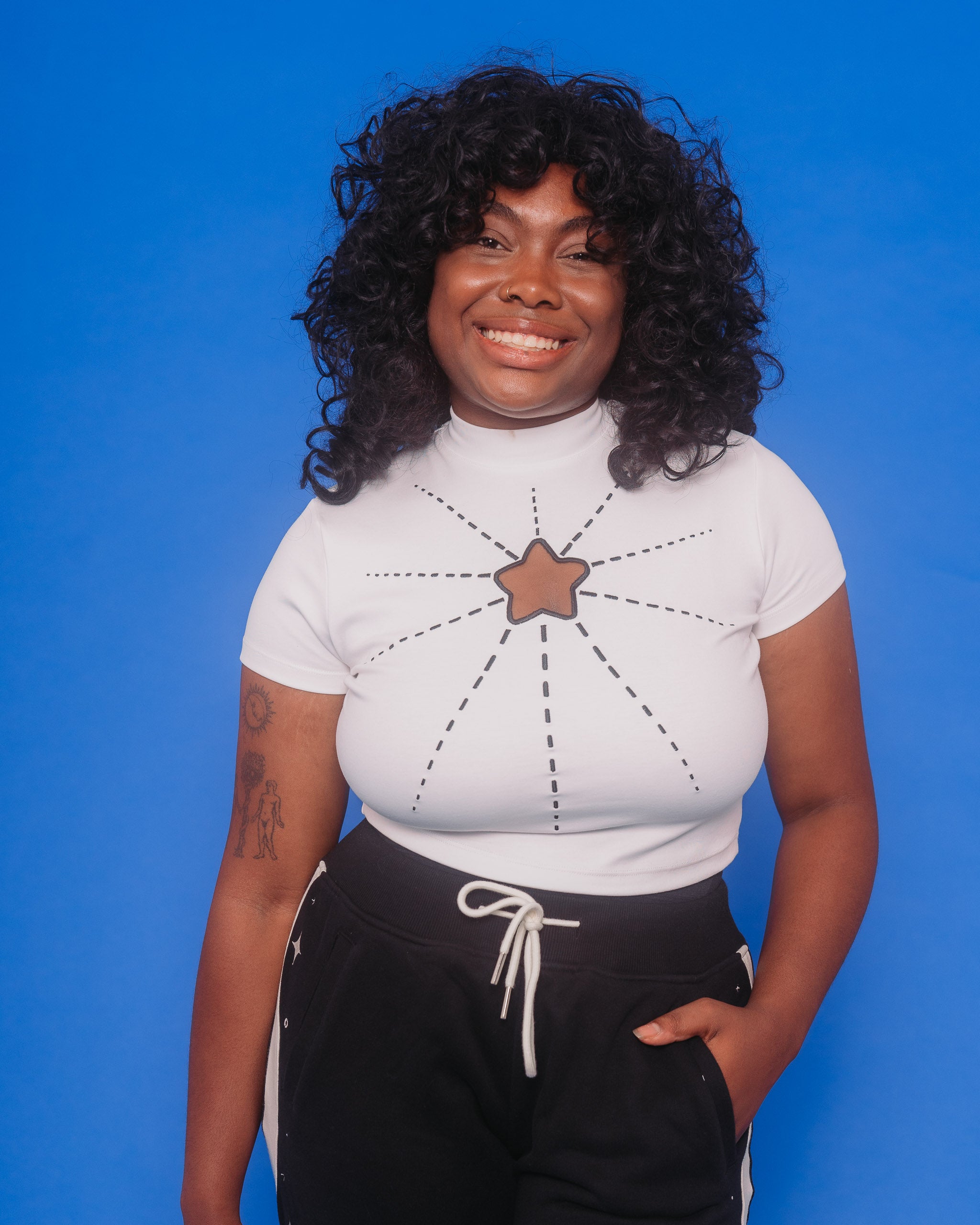 Woman wearing white supernova mini tee in size large in front of blue background.