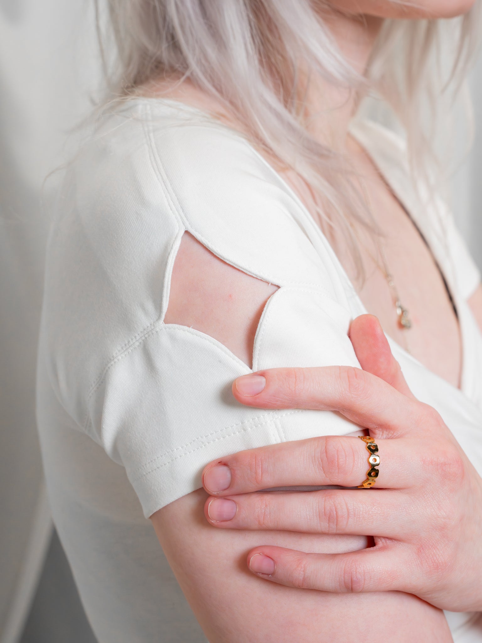 Close up of supernova (white) cap sleeve sparkle cut out with model's hand placed just below, wearing a gold bloomsday daisy ring.