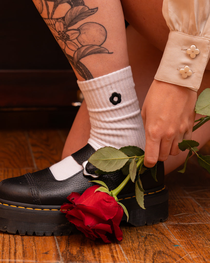 Close up of sweetheart white bolero flower buttons on cuff.