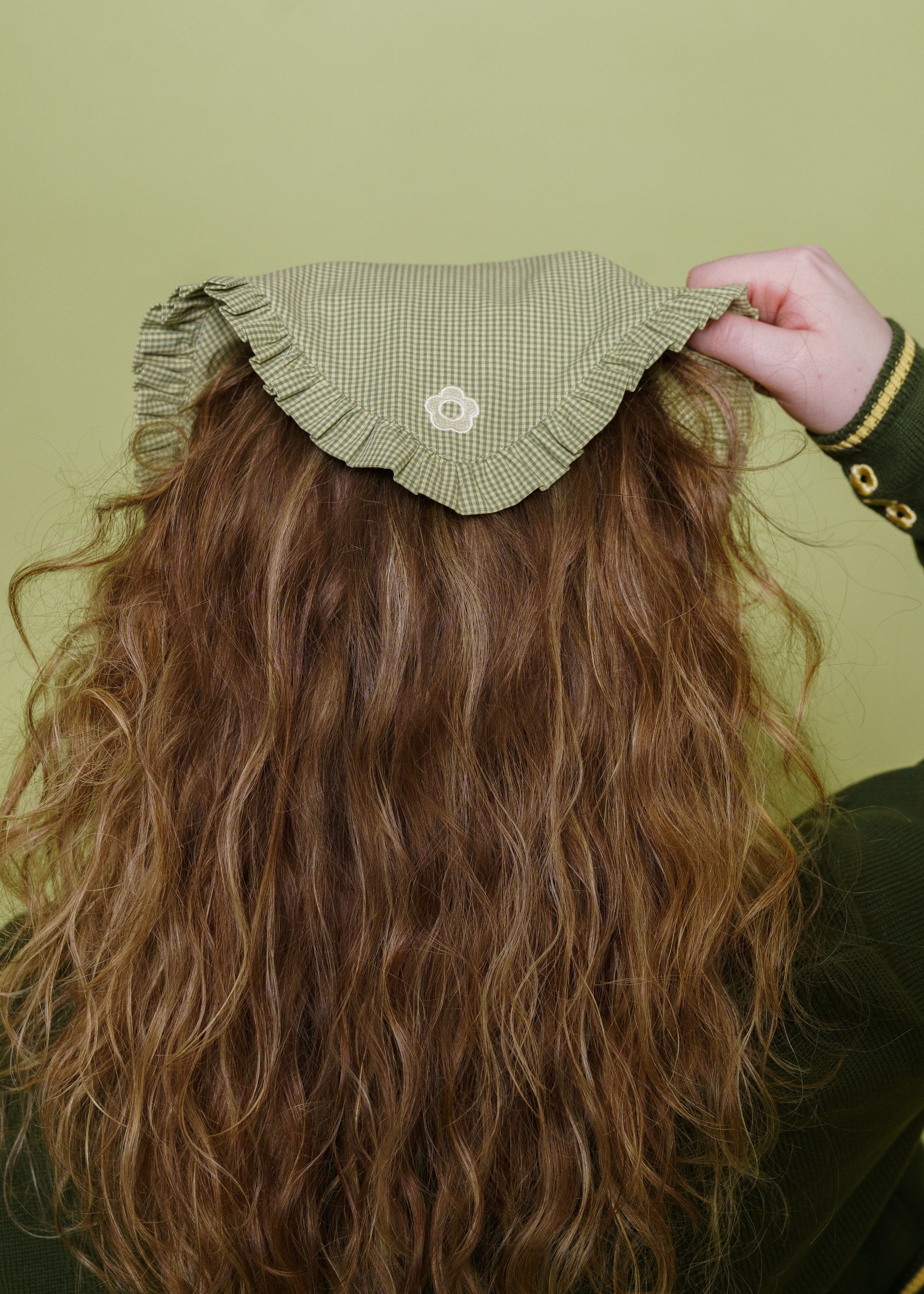 Close up of teahouse bandanna in loose leaf showing embroidered daisy detail.