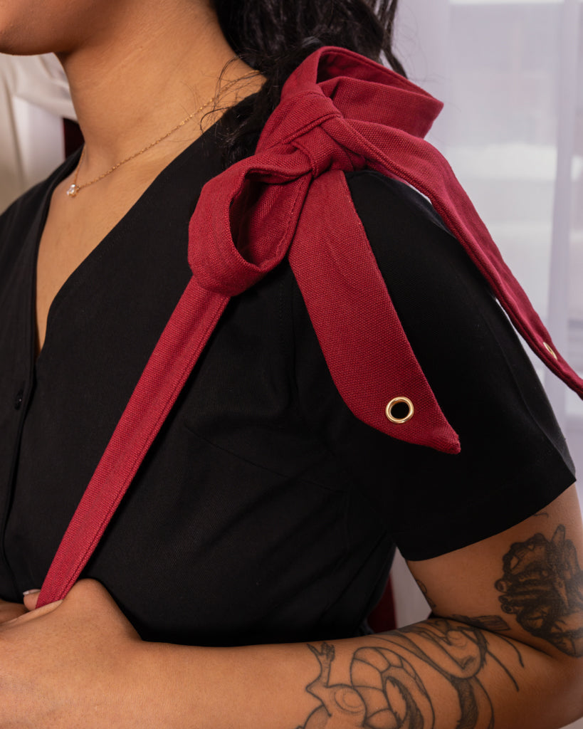 Close up of tongue tied red tote bag bow strap.